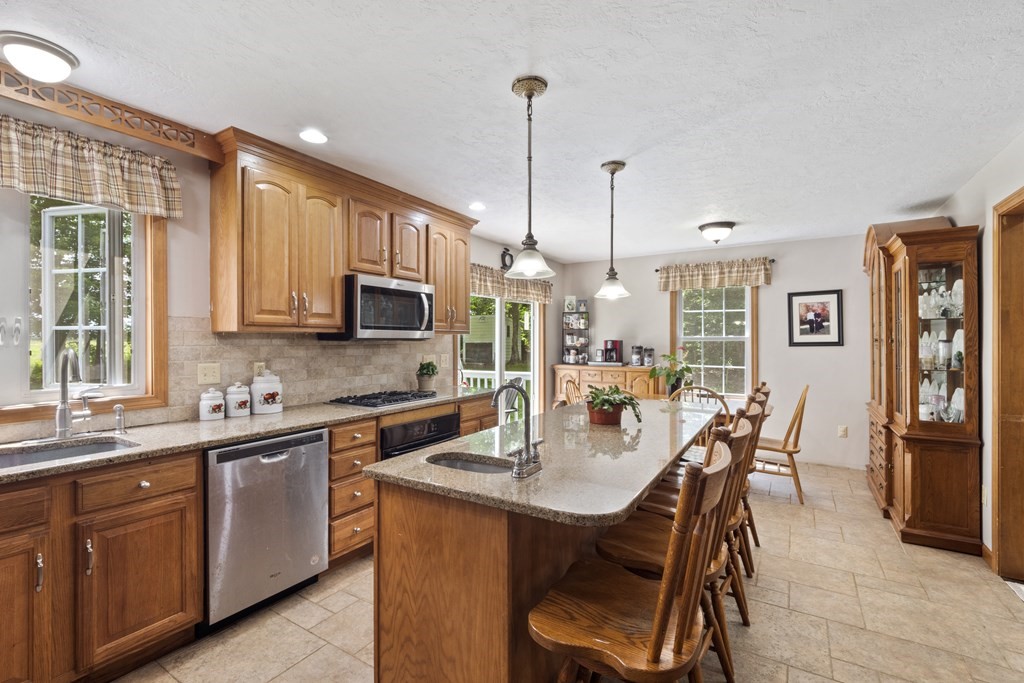 4 Huntington Road Blandford, MA 01008 - Photo 16 of 27 a kitchen with stainless steel appliances granite countertop a stove a sink a microwave a dining table and chairs