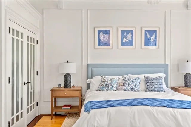 a bedroom with a bed and painting on the wall