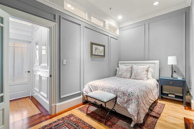 a bedroom with a bed and a lamp on dresser