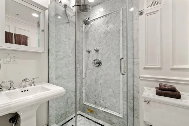 a bathroom with a sink a toilet and shower