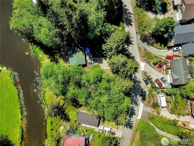 an aerial view of residential house with outdoor space and trees all around