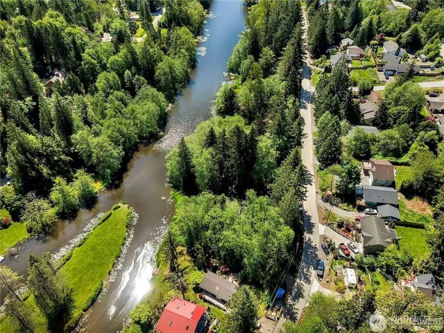 an aerial view of residential house with outdoor space and trees all around