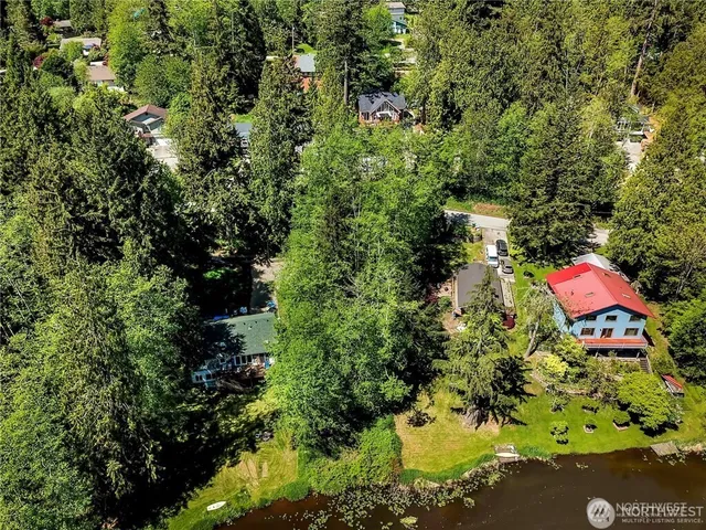 an aerial view of residential house with outdoor space and trees all around