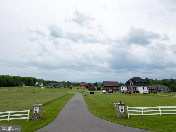 a view of a grassy field with houses in the background