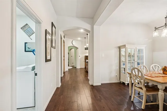 a view of a hallway with wooden floor and furniture