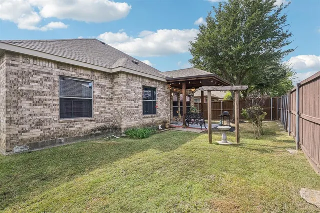 a backyard of a house with table and chairs