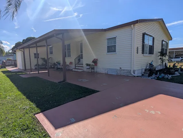 a view of a house with backyard and sitting area