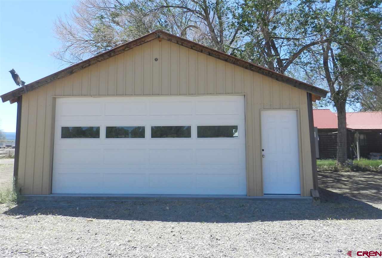 1720 6450 Road, Unit FINISHED GARAGE B Montrose, CO 81401 - Photo 2 of 8 a front view of a house with a yard