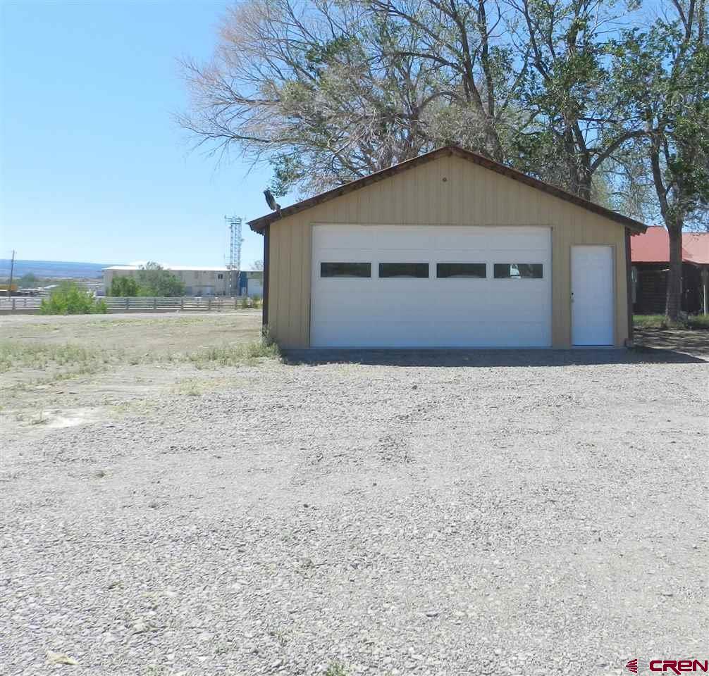 1720 6450 Road, Unit FINISHED GARAGE B Montrose, CO 81401 - Photo 3 of 8 a house with trees in the background