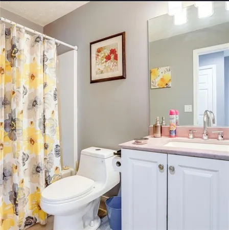 a bathroom with a sink mirror vanity and toilet