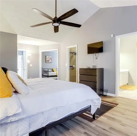 a bedroom with a bed and a flat tv screen on dresser