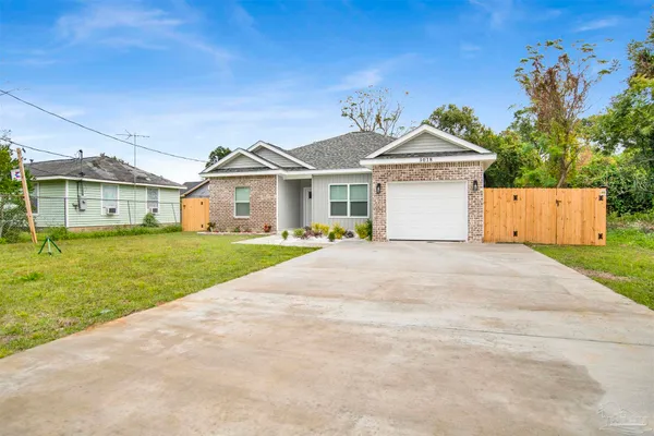 a front view of a house with a garden and yard