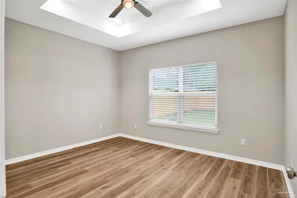 an empty room with a window and wooden floor