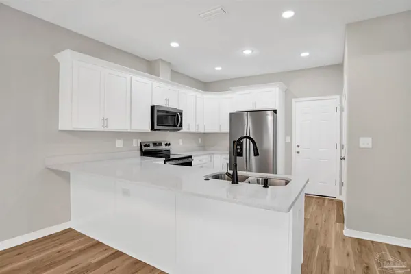 a kitchen with a sink a refrigerator and cabinets