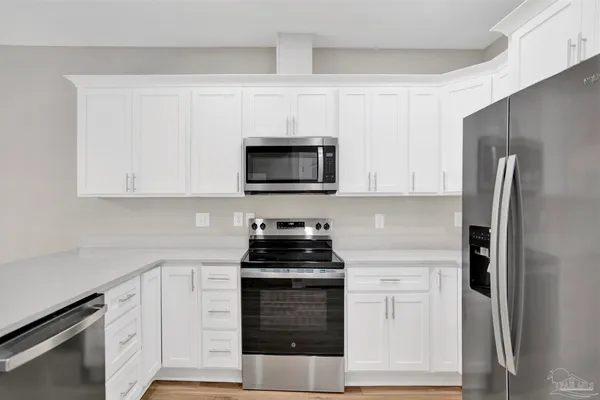 a kitchen with white cabinets and stainless steel appliances