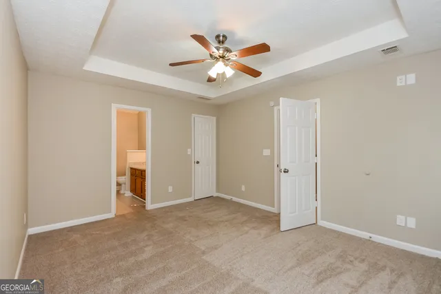 an empty room with closet and ceiling fan