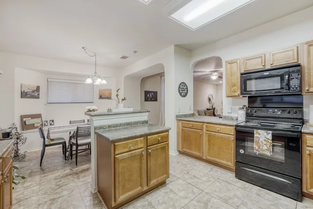 a kitchen with stainless steel appliances granite countertop a sink stove and cabinets