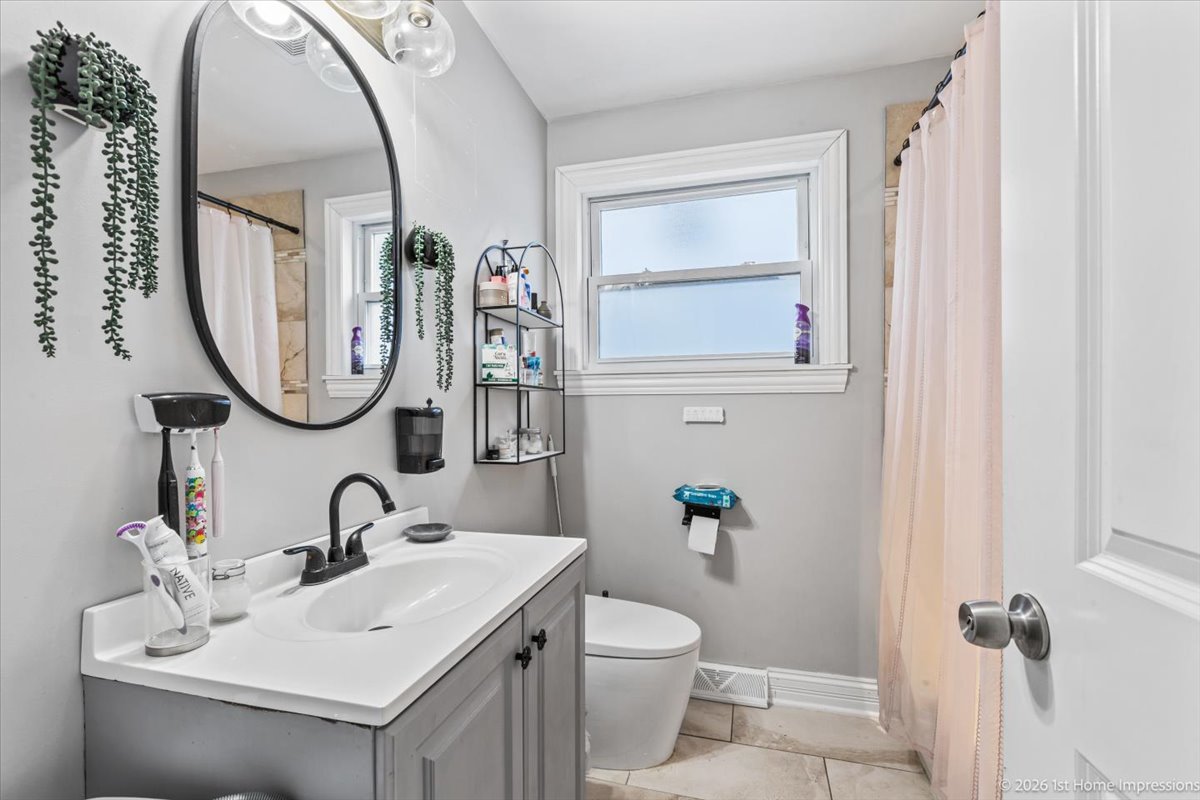7205 South Hamlin Avenue Chicago, IL 60629 - Photo 13 of 24 a bathroom with a toilet sink and mirror