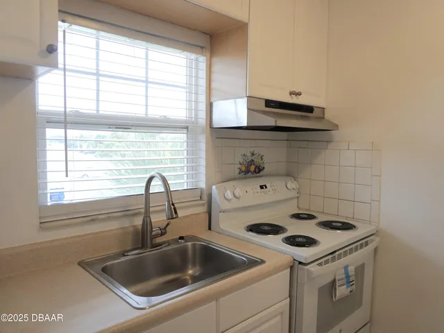 a close view of a sink and dishwasher with kitchen island