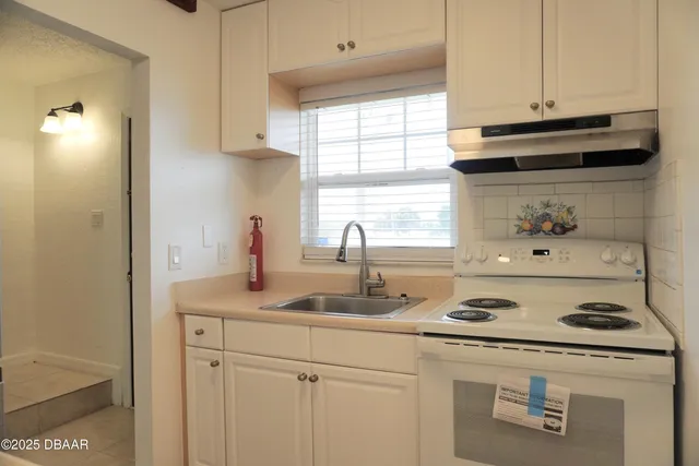 a kitchen with a sink a stove and cabinets