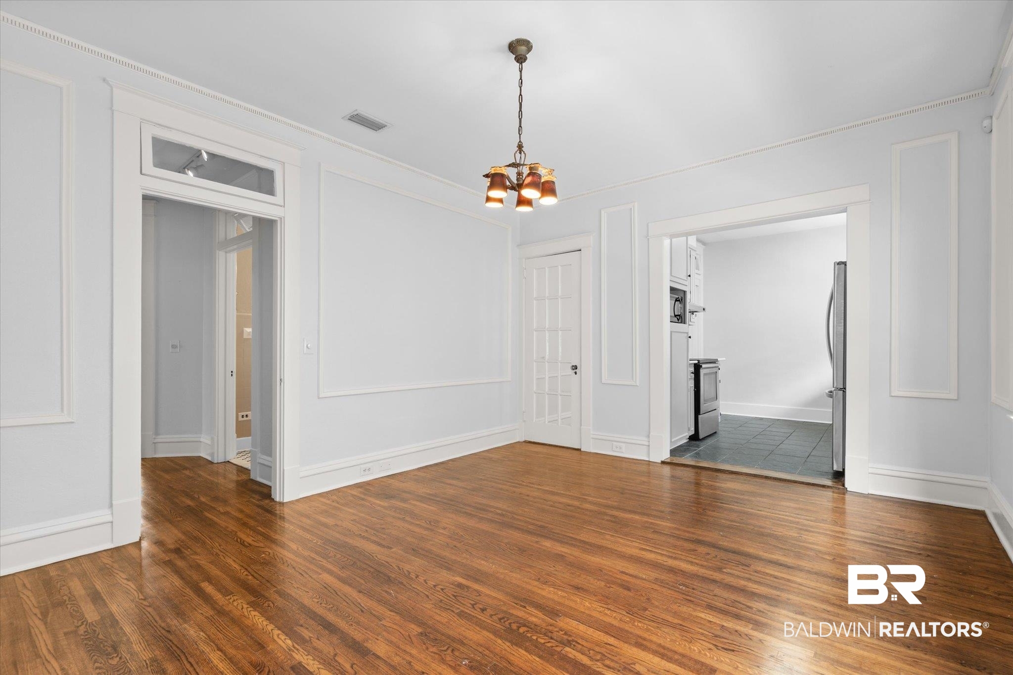 24 Macy Place Mobile, AL 36604 - Photo 11 of 38 Unfurnished room featuring a chandelier, dark wood-type flooring, baseboards, and ornamental molding