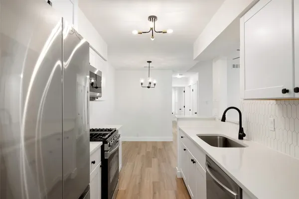 a kitchen with stainless steel appliances a sink a stove and refrigerator