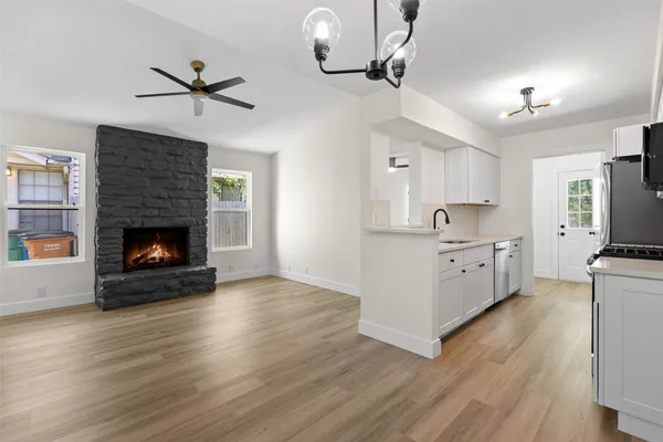 a kitchen with stainless steel appliances a stove top oven a sink a refrigerator and chairs