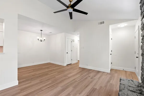 a view of a room with wooden floor and ceiling fan