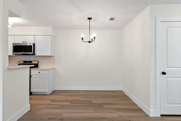 a view of a kitchen with wooden floor and a sink