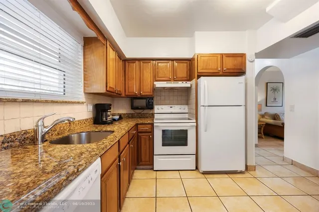 a kitchen with a sink a refrigerator and cabinets