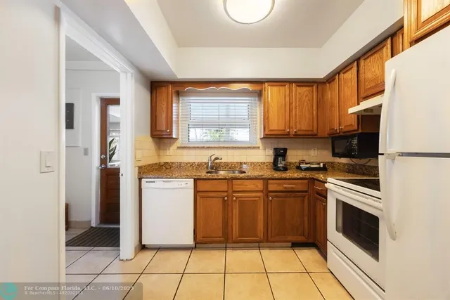 a kitchen with a sink a stove top oven and stainless steel appliances