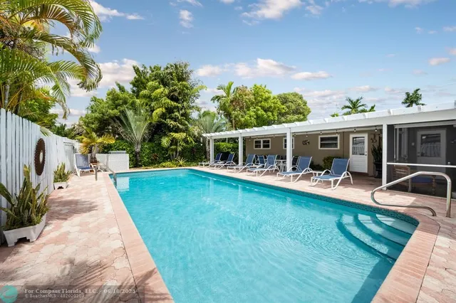 a view of house with swimming pool having outdoor seating