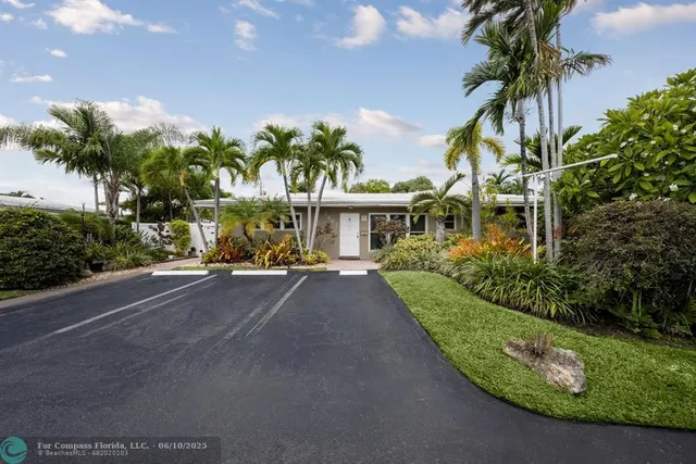 a view of a house with a yard and potted plants
