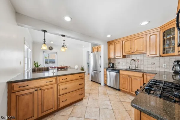 a kitchen with stainless steel appliances granite countertop a stove sink and cabinets