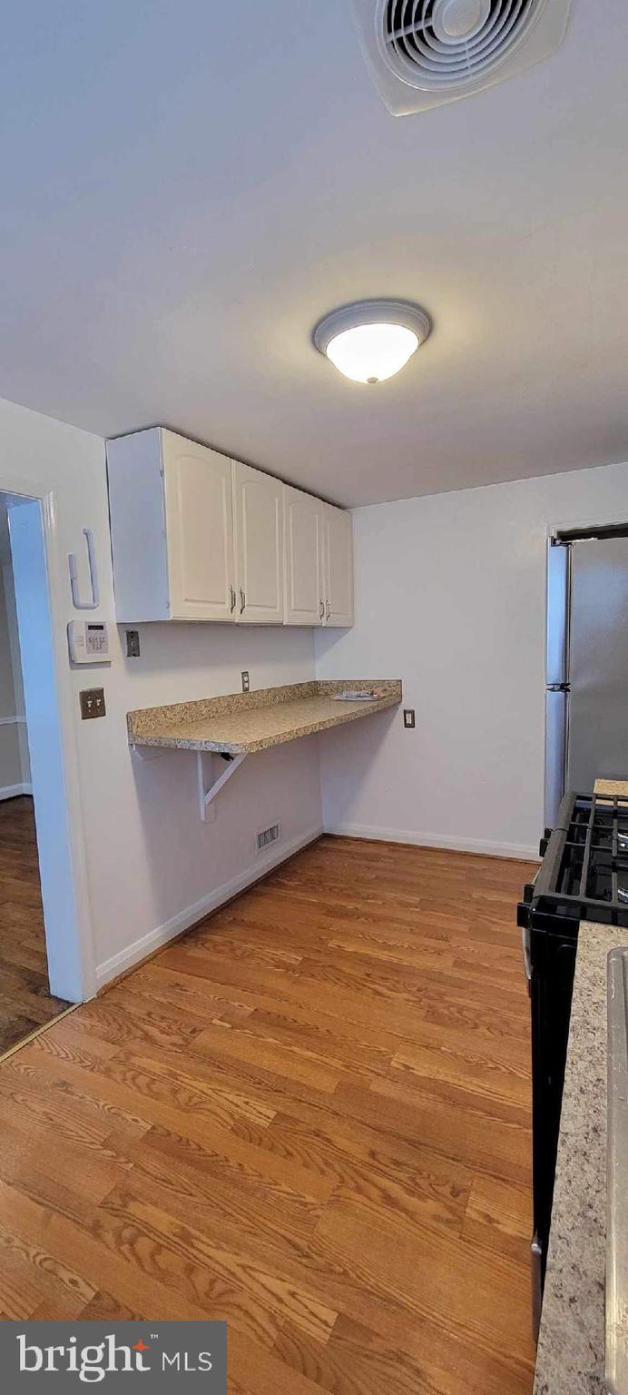 8203 Lasalle Road Towson, MD 21286 - Photo 6 of 17 a view of kitchen and empty room with wooden floor