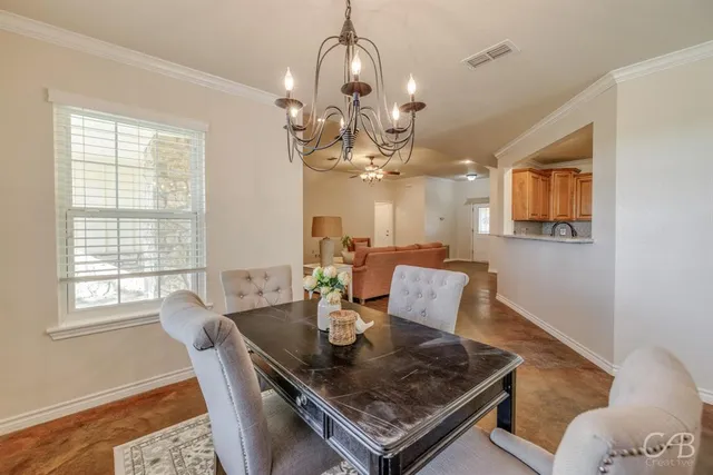 a view of a dining room with a table and chairs