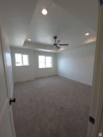 1267 West 2350 South Perry, UT 84302 - Photo 18 of 20 Spacious room featuring a tray ceiling with recessed lighting and a ceiling fan
