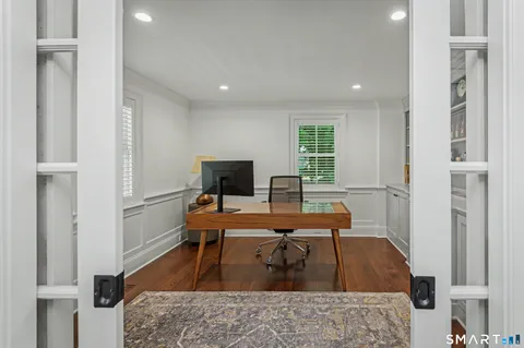a view of a workspace with furniture and a book shelf
