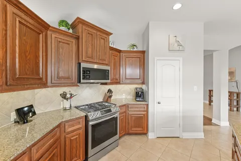 a kitchen with stainless steel appliances granite countertop a stove a sink and a refrigerator