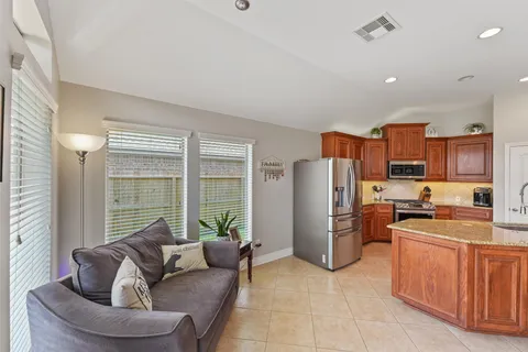a living room with furniture a refrigerator and a kitchen