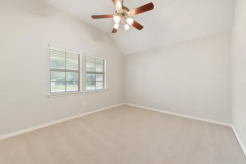 an empty room with a window and a fan