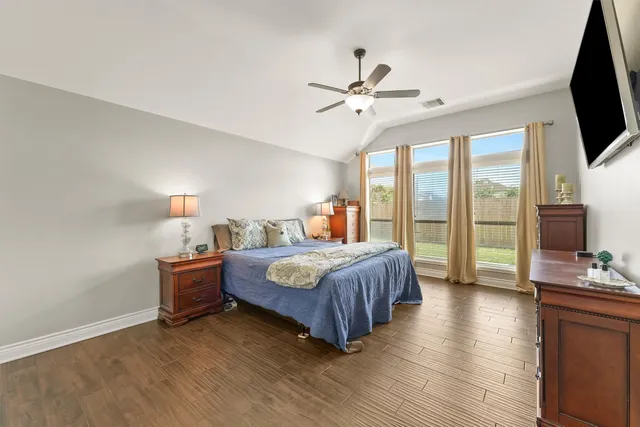 a bedroom with a bed flat screen tv and a large window