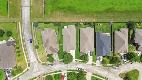 an aerial view of a city with lots of green space and houses