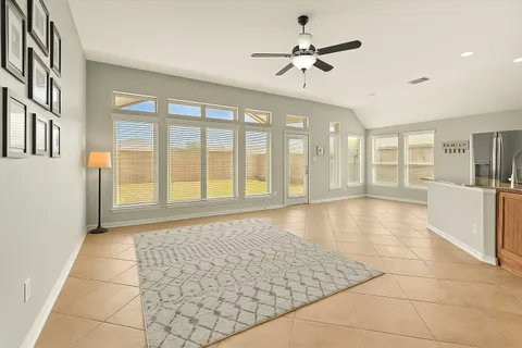 a view of an empty room with a window and a kitchen