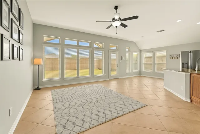 a view of an empty room with a window and a kitchen