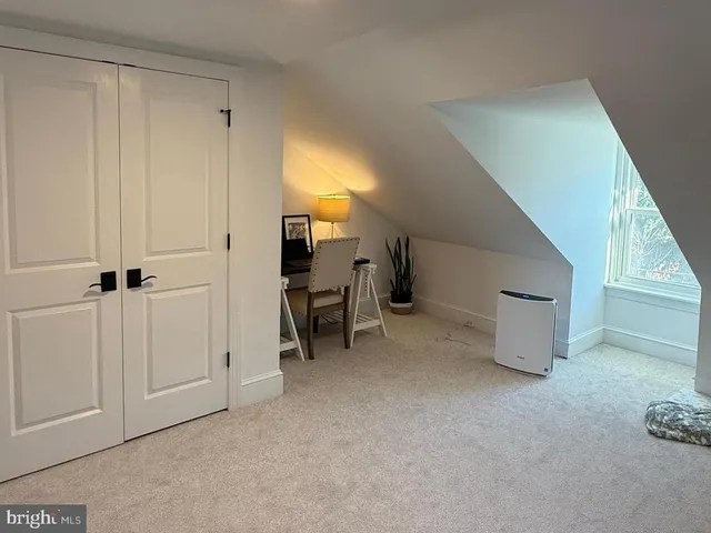 a bed sitting in a spacious bedroom next to a window