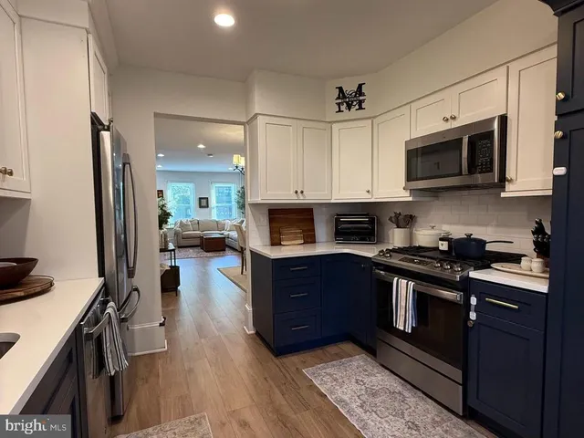 a kitchen with stainless steel appliances kitchen island granite countertop a stove a sink and a microwave