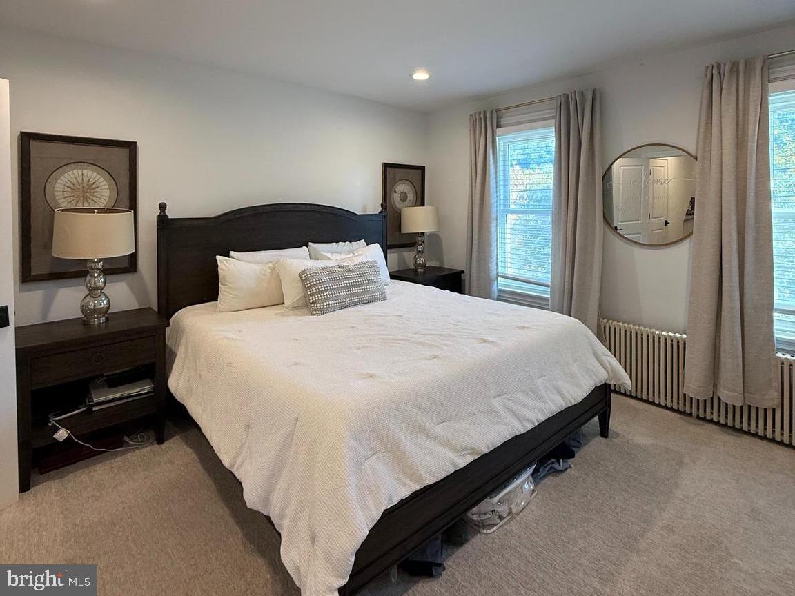 810 East Elm Street Conshohocken, PA 19428 - Photo 8 of 18 a large bed sitting in a bedroom and a mirror