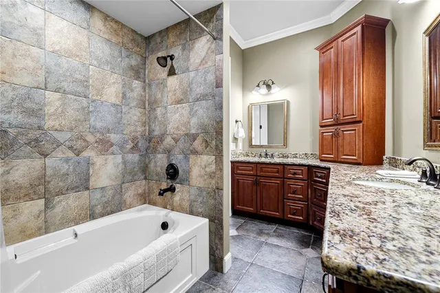 a bathroom with a granite countertop tub sink and mirror