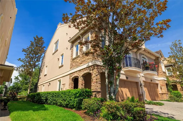 a front view of a multi story residential apartment building with yard and parking space